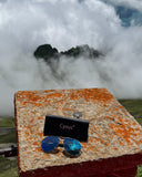 Cyxus sunglasses and case on a rocky surface with clouds in the background