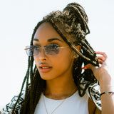 Woman with braided hair wearing rimless photochromic glasses 8127 and a white top against a light background