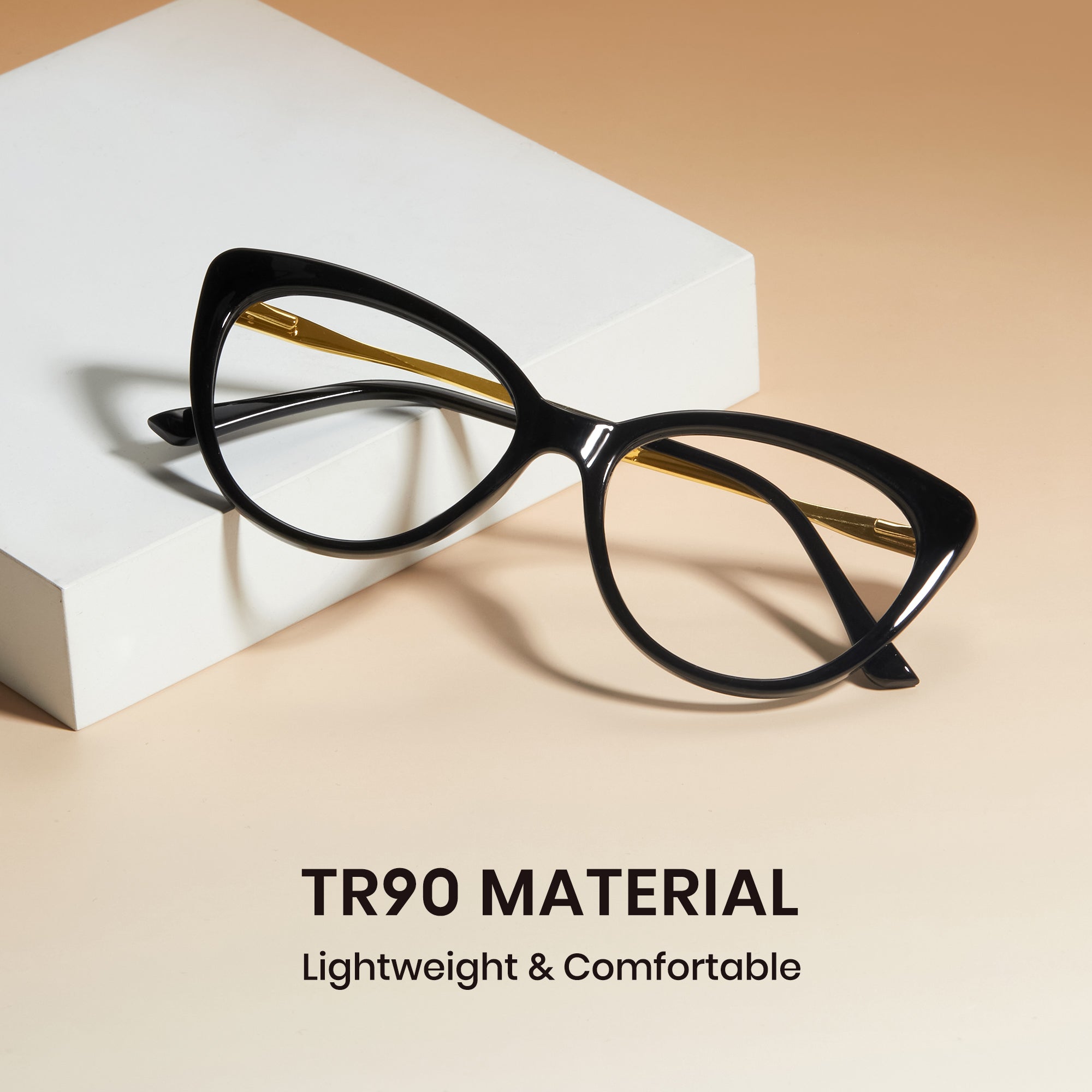 Black cat-eye glasses on a white block with 'TR90 Material' text on a beige background