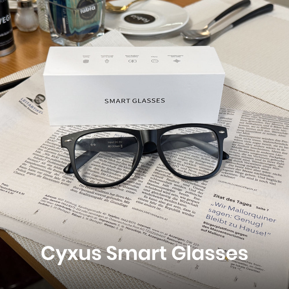 Cyxus Smart Glasses on a newspaper with packaging in the background