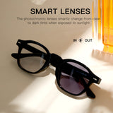 Black eyeglasses with smart lenses changing from clear to dark on a beige background.