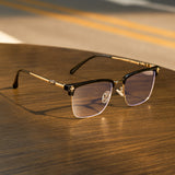 Cyxus 8252 eyeglasses with gold frame on a wooden surface