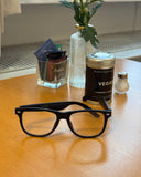 Cyxus smart glasses 8284 on a wooden surface with a can labeled 'Vegan' and other items in the background.