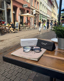 Cyxus smart glasses 8284 on a notebook with case on a table in an outdoor cafe setting