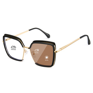 Glossy black oversized photochromic blue light glasses, gold metal temples, white to tea lens