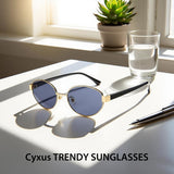 Trendy sunglasses on a table with a pen and glass of water, featuring the brand 'Cyxus'.