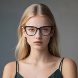 Woman wearing black glasses against a gray background