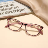 Pink cat-eye glasses on a newspaper with a beige background